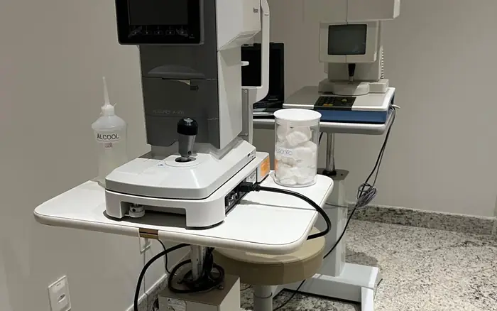Perímetro Octopus e autorrefrator na sala de exames da clínica, equipamentos usados no acompanhamento do glaucoma.